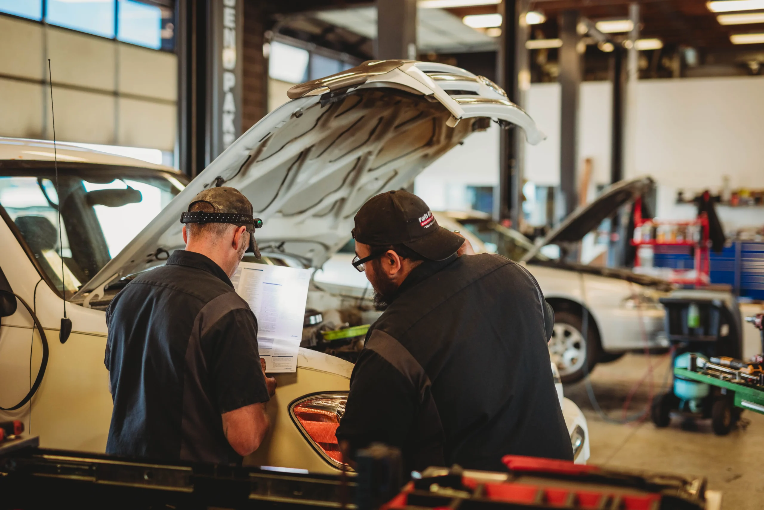 "Two mechanics diagnosing a vehicle at Jer's Elite Automotive, a leading mechanical shop in Syracuse, Utah, providing expert automotive services."